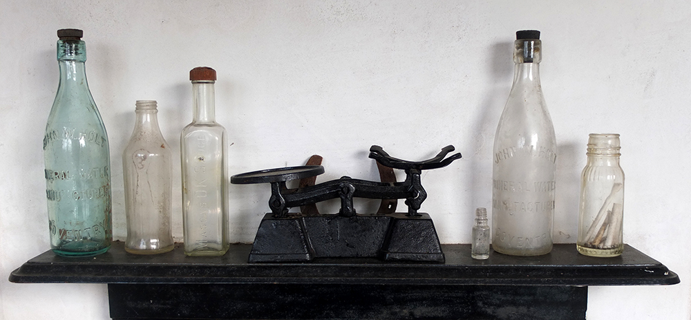 antique glass bottles on a cast iron mantelpiece